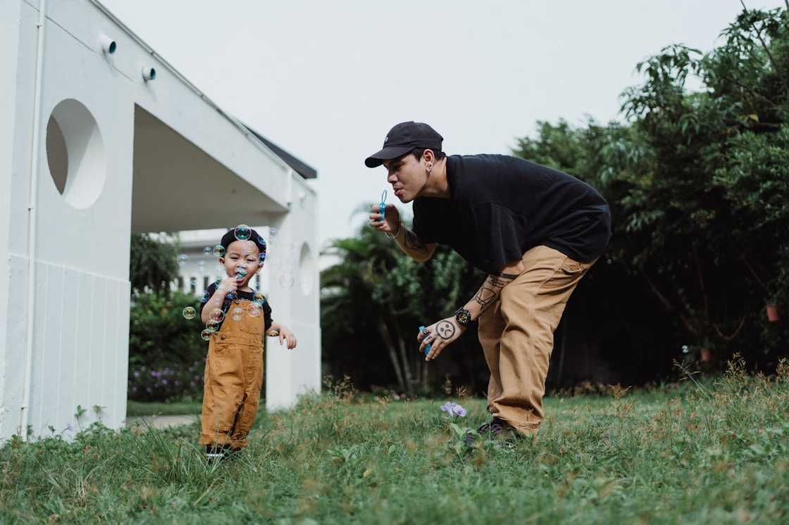 A man plays with a child outdoors. A man plays with a child outdoors.