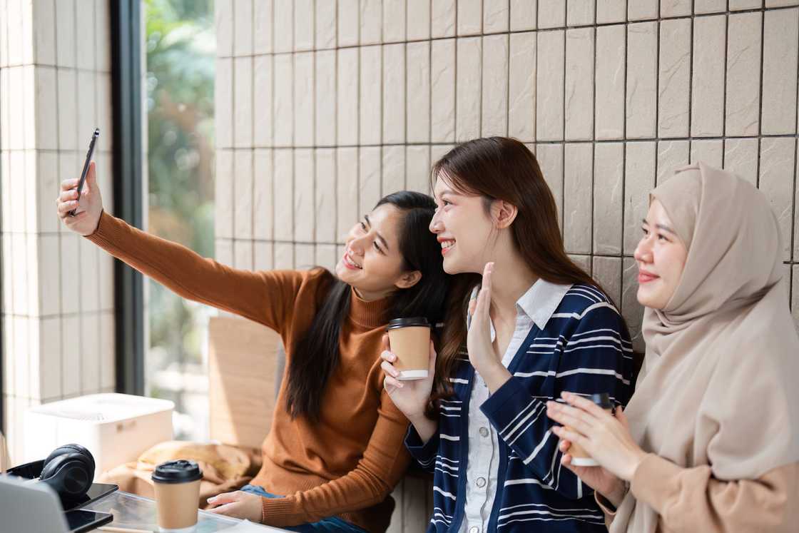 Three students taking a selfie during a group study session