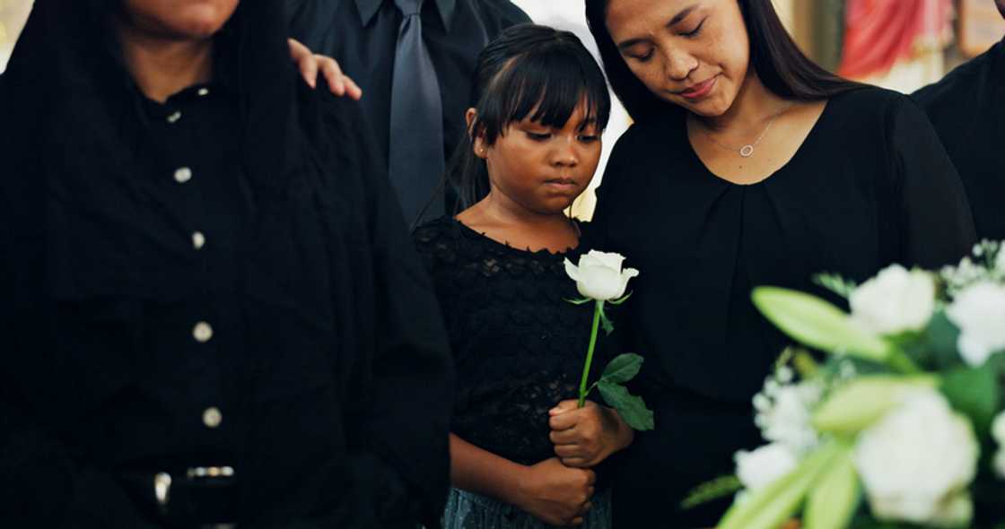 Two women stand apart at a funeral. Two women stand apart at a funeral.