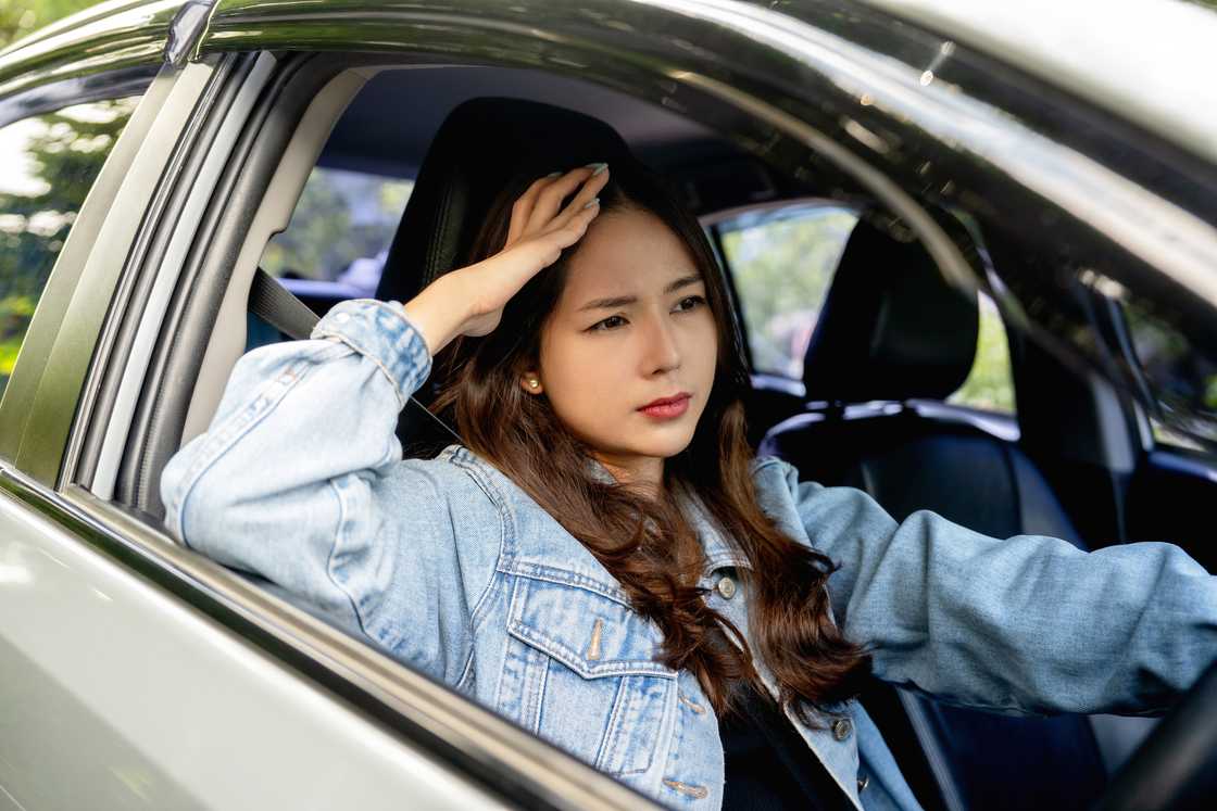 A frustrated woman driving, seemingly worried