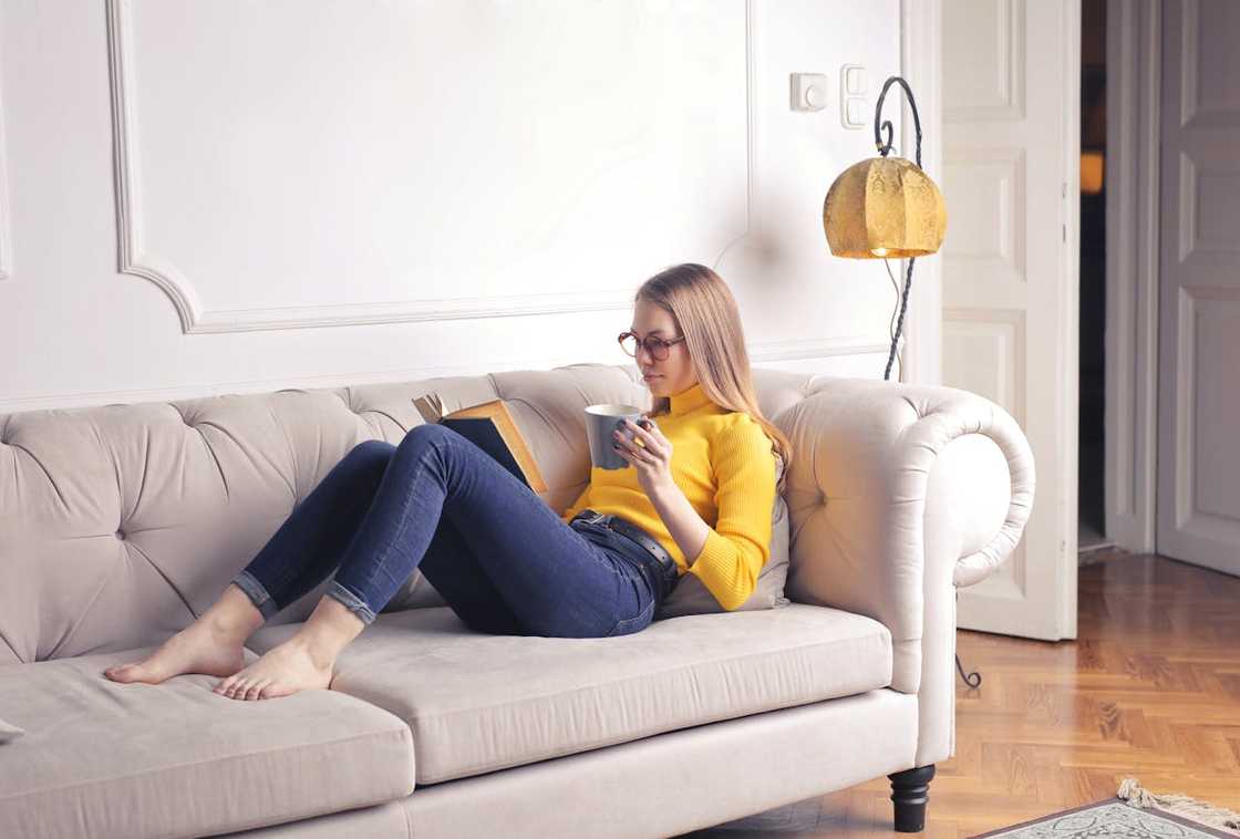 A woman poses in with a coffee cup.
