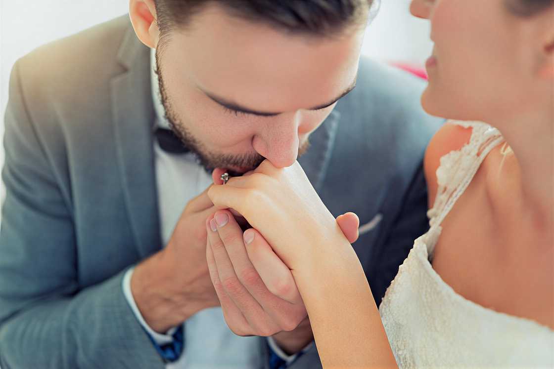 An Asian man kissing a woman's hand