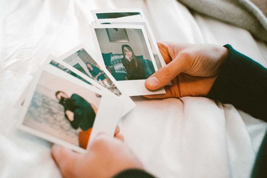 A person holds small printed photographs.
