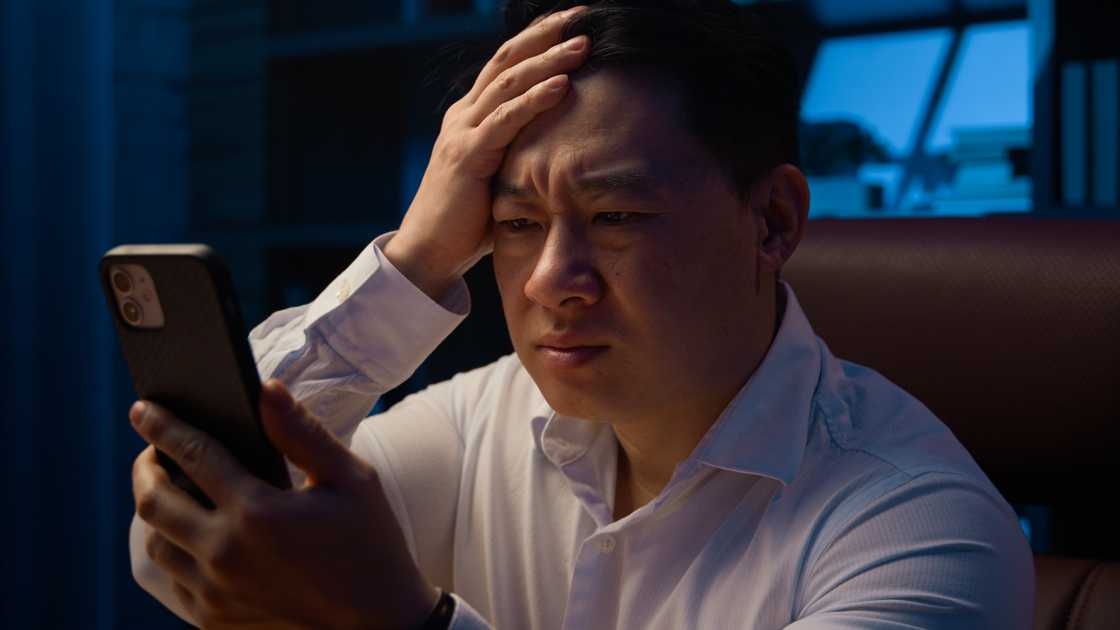 a shocked man looking at his phone at night a shocked man looking at his phone at night