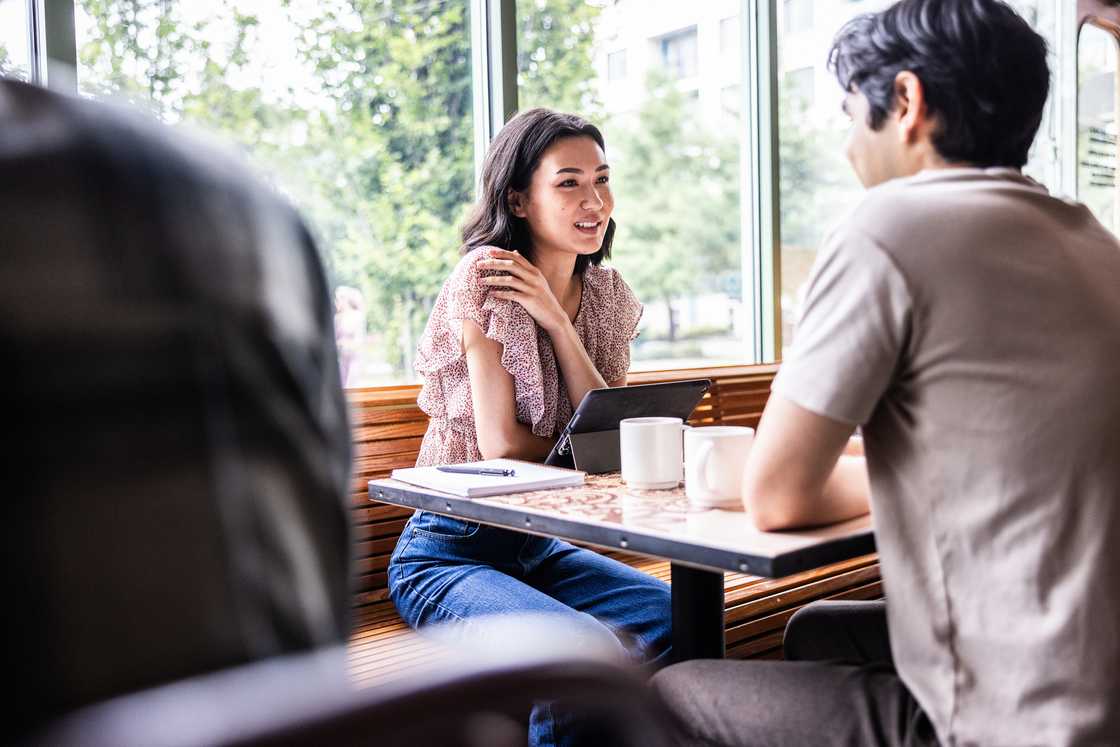 A man and woman at a cafe chatting A man and woman at a cafe chatting