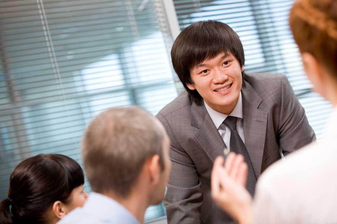 Several employees discussing something with focus on their leader Several employees discussing something with focus on their leader