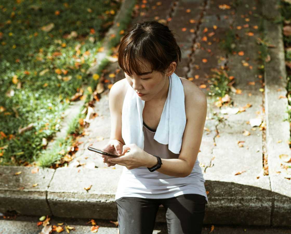 A serious young woman typing outdoors A serious young woman typing outdoors