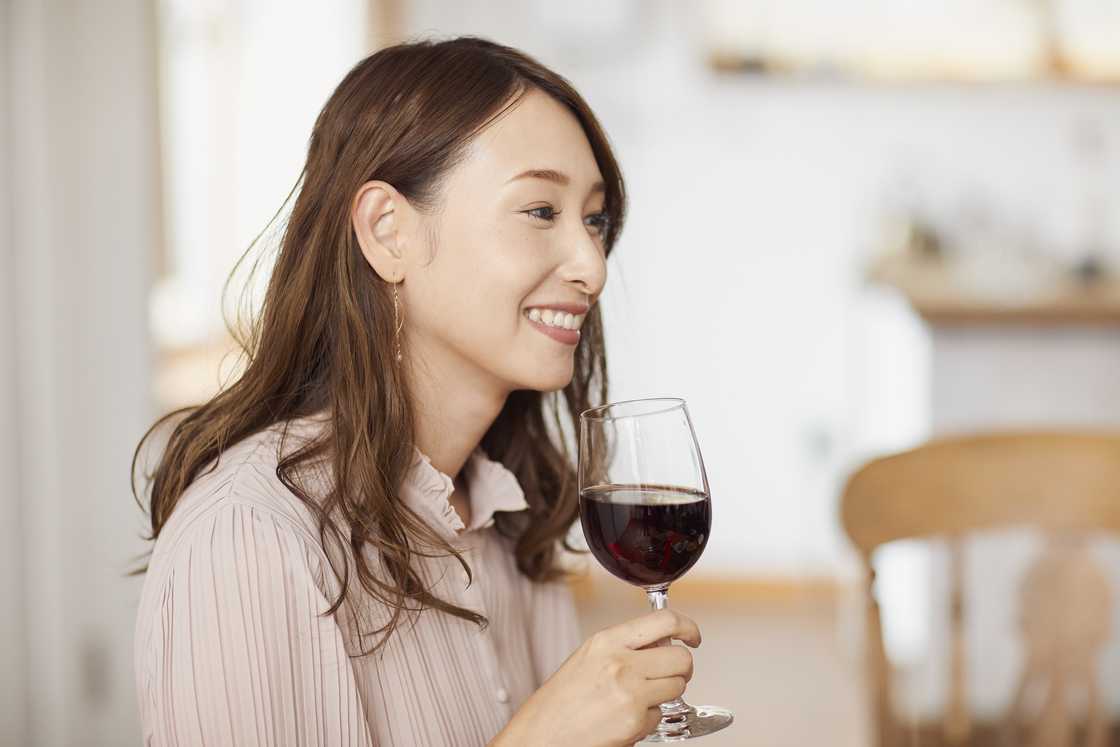 A lady holds a glass of red wine