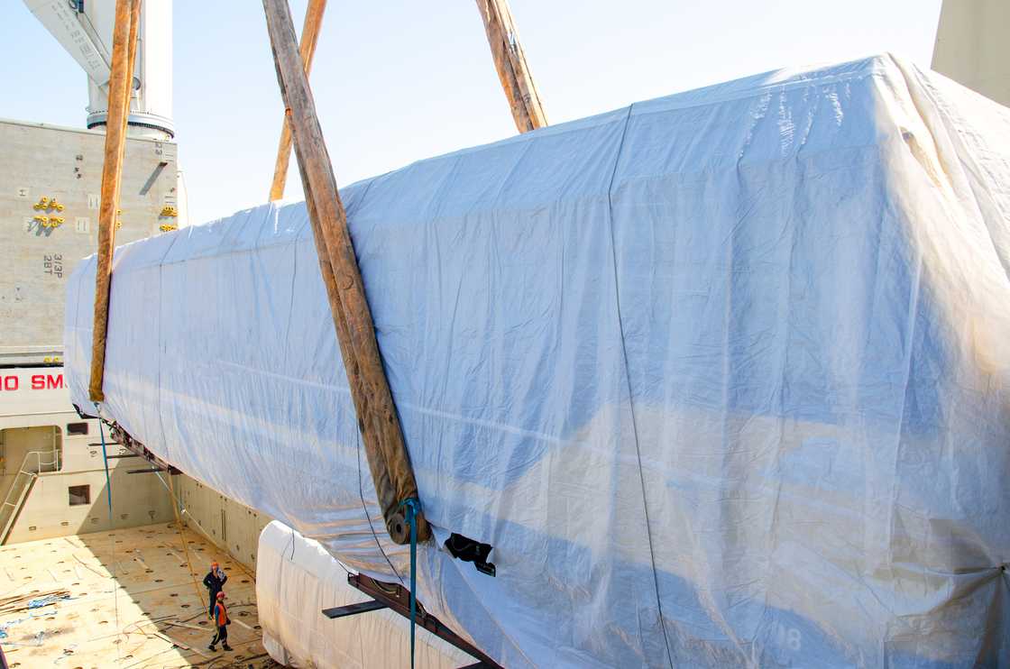 A covered vehicle is lowered beside a mausoleum during a symbolic burial. A covered vehicle is lowered beside a mausoleum during a symbolic burial.