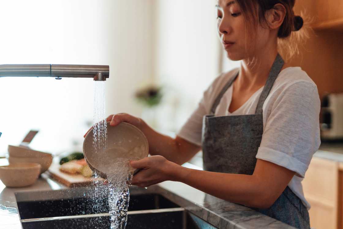 A woman is washing dishes A woman is washing dishes