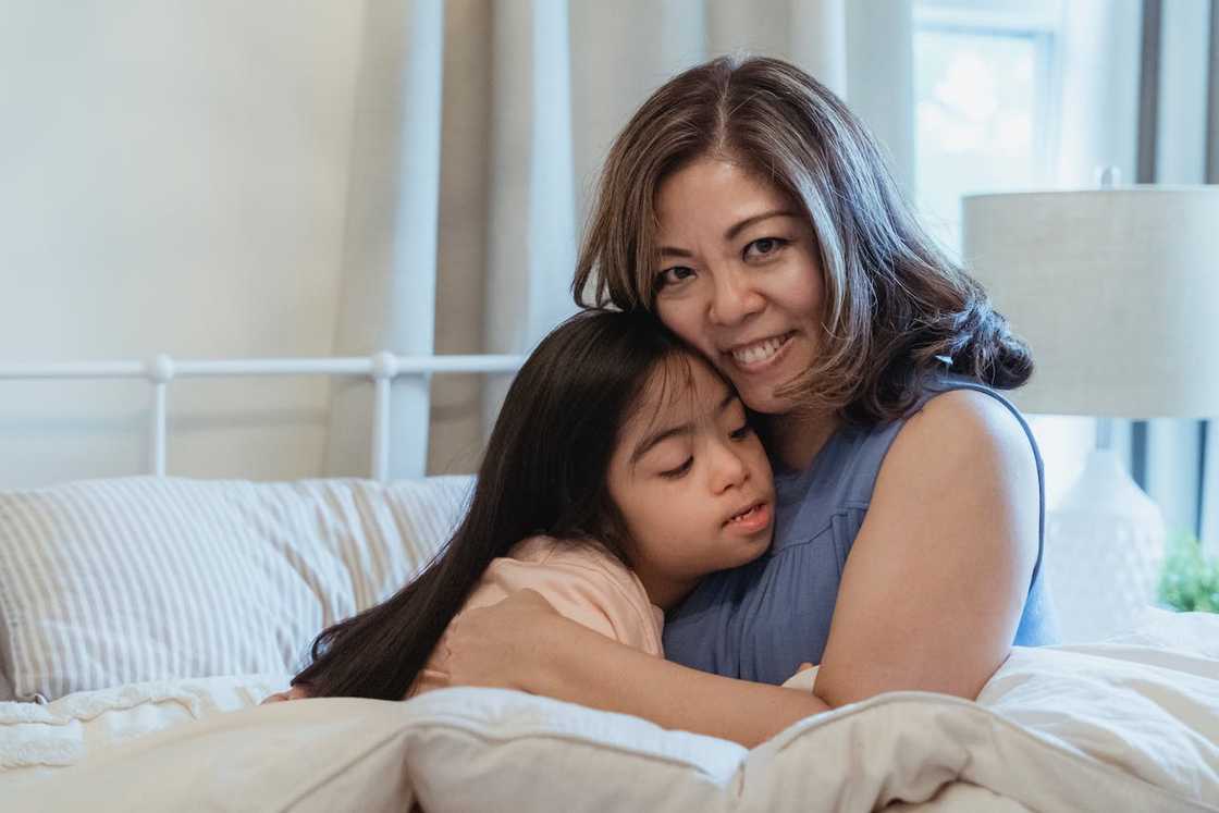 A mother and her daughter hug each other at home.