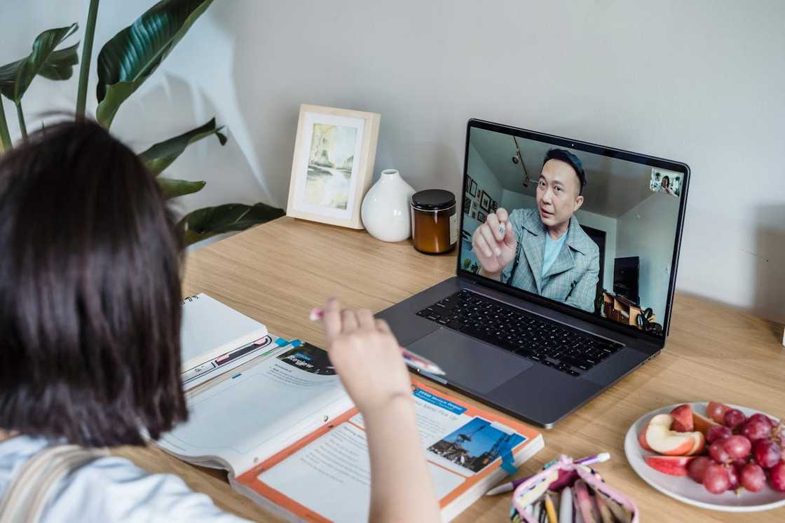 A young girl talks on a video call with her father.