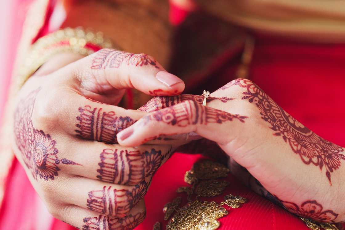 A muslim woman touching the ring finger