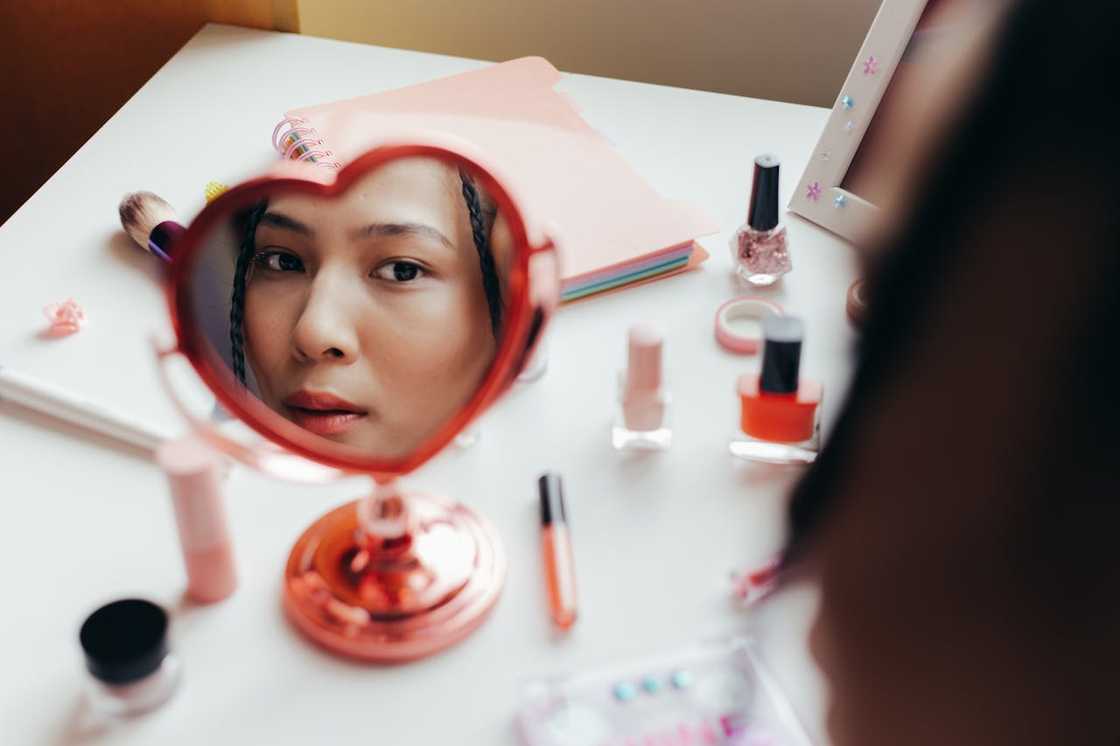 A woman removes makeup on her face.
