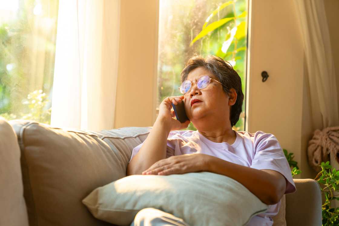 An elderly woman is making a call An elderly woman is making a call
