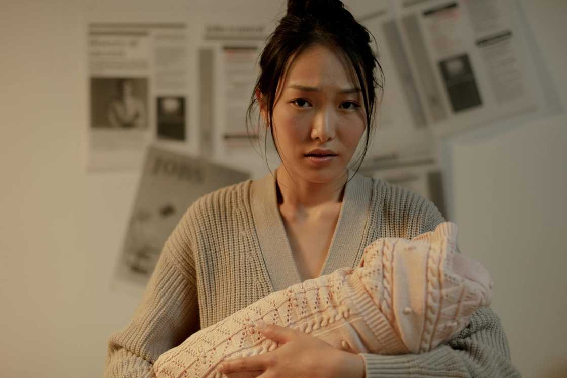 A young mother holding her newborn lovingly. A young mother holding her newborn lovingly.