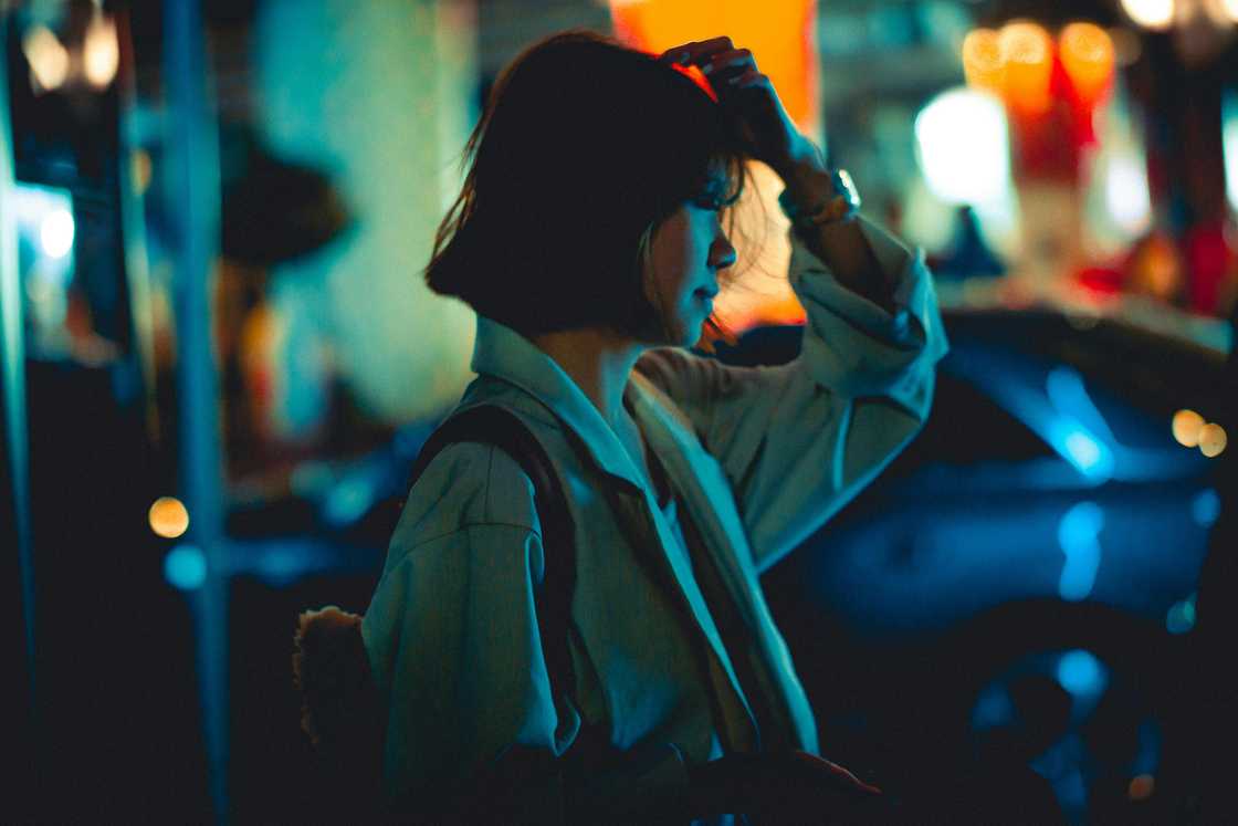 Young woman standing on a busy street at night