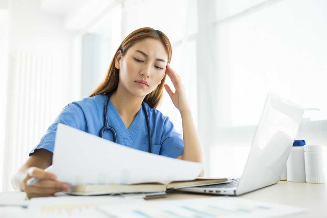 A female doctor reading a document while frowning