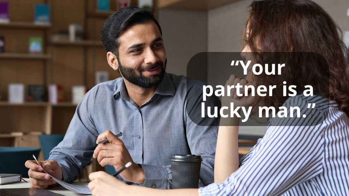 A manager looking at female colleague chatting in office A manager looking at female colleague chatting in office