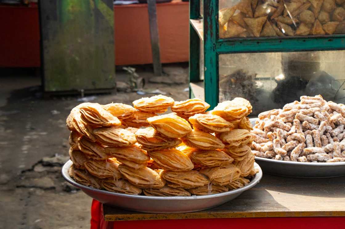 Stacks of fried pastries being displayed at a street food stand. Stacks of fried pastries being displayed at a street food stand.
