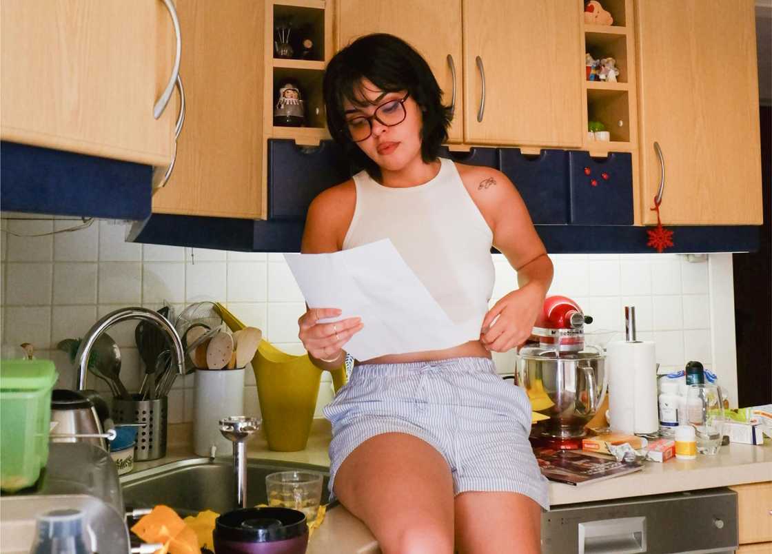 A woman reads a letter at home.