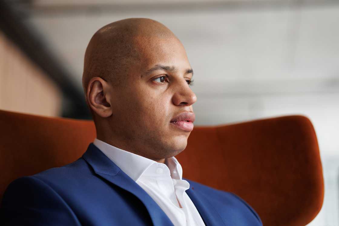 A businessman sitting in a armchair in a hotel lobby.