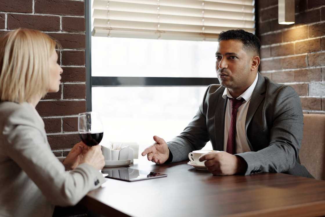 A woman and a man talk during a café meeting. A woman and a man talk during a café meeting.