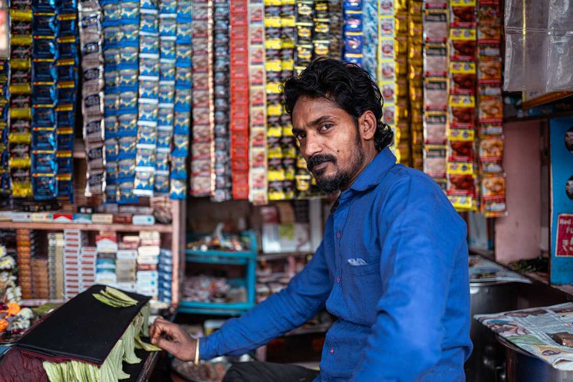 A smiling shop owner inside a packed neighbourhood shop. A smiling shop owner inside a packed neighbourhood shop.