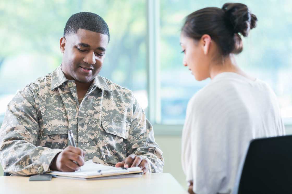 Security personell listening as he records on paper Security personell listening as he records on paper