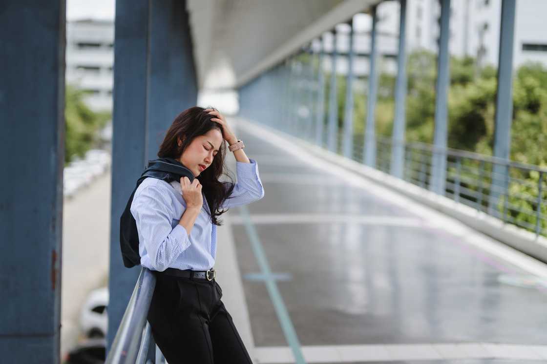 A sad woman standing outside