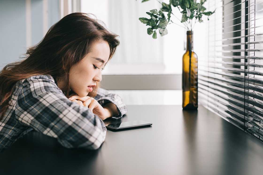 A young woman staring at her smartphone