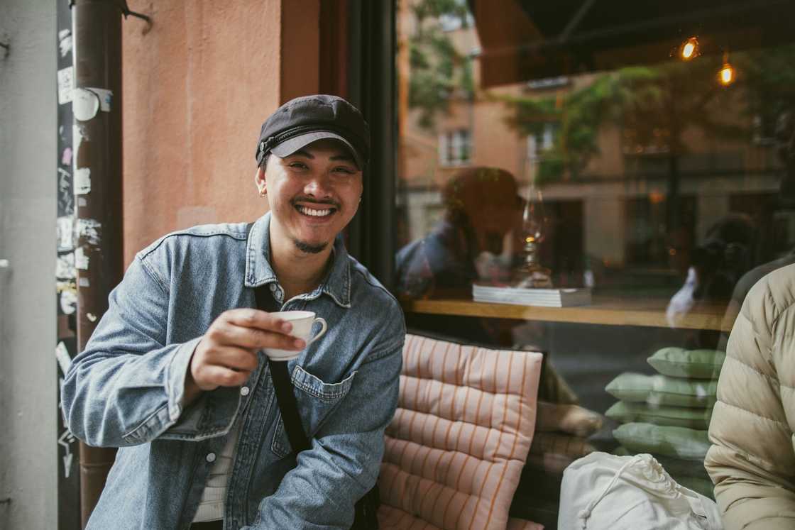 Asian man drinking coffee shop smiling Asian man drinking coffee shop smiling