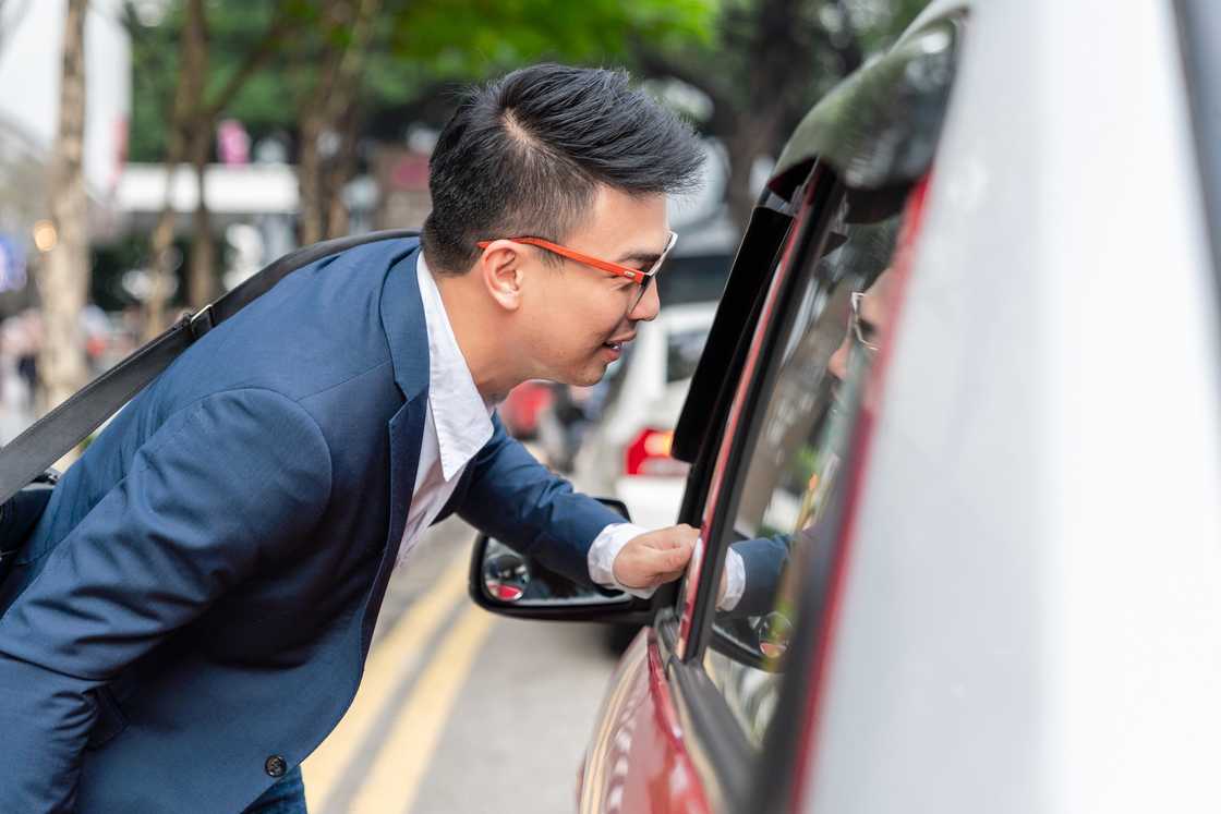A man talking to a driver through a car window