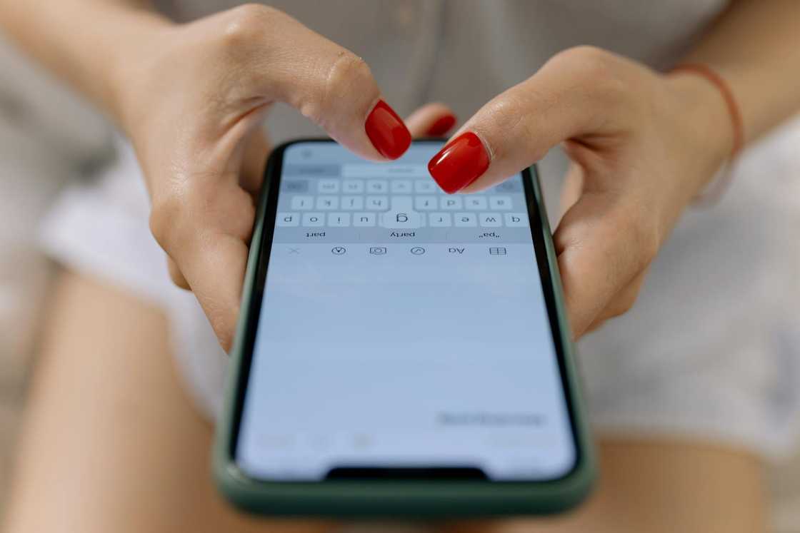 A woman types on her smartphone.