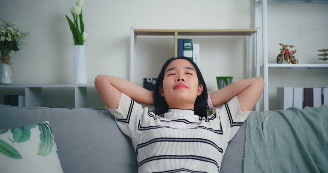 An Asian woman resting comfortably on the sofa in the living room. An Asian woman resting comfortably on the sofa in the living room.