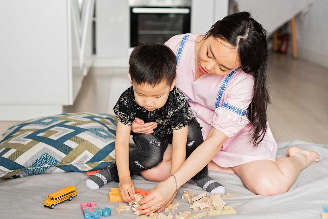 A mother and son playing with toys. A mother and son playing with toys.
