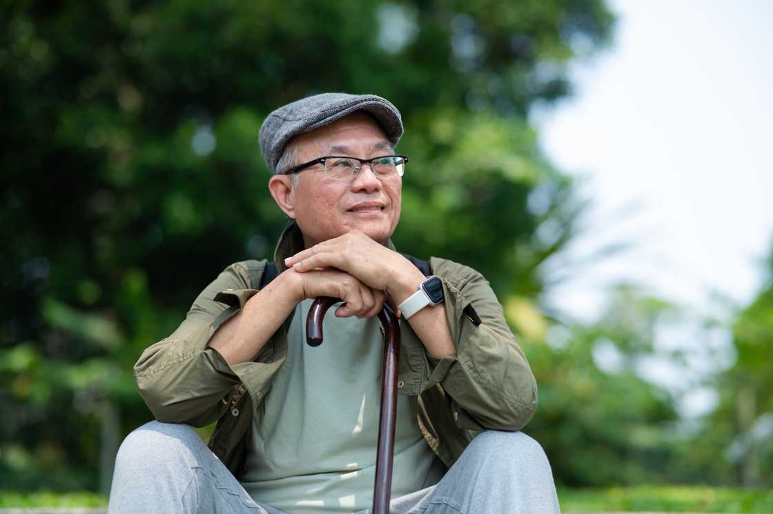 A man with a walking stick reflecting A man with a walking stick reflecting