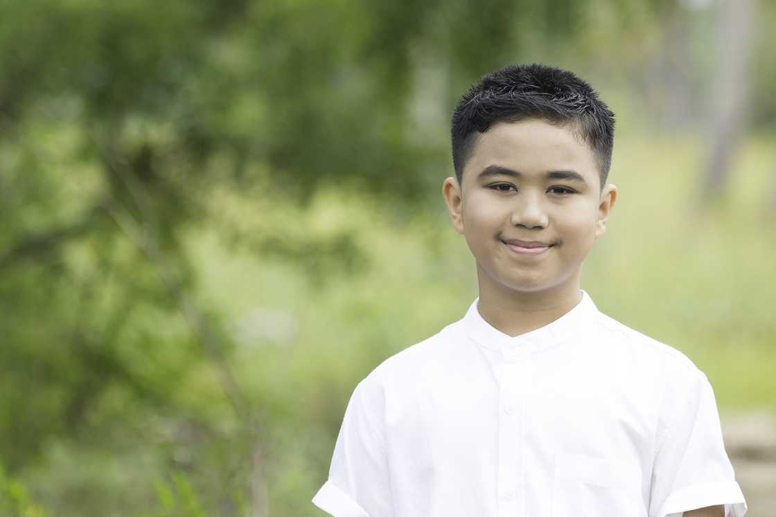 A boy wearing a white shirt smiling