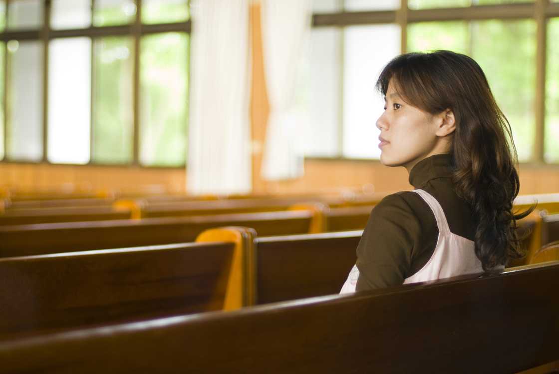 A young woman sitting in a church.