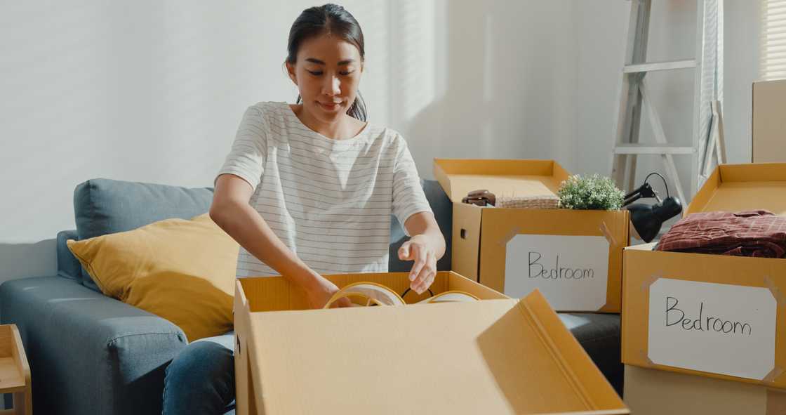 Young woman unpacking box Young woman unpacking box