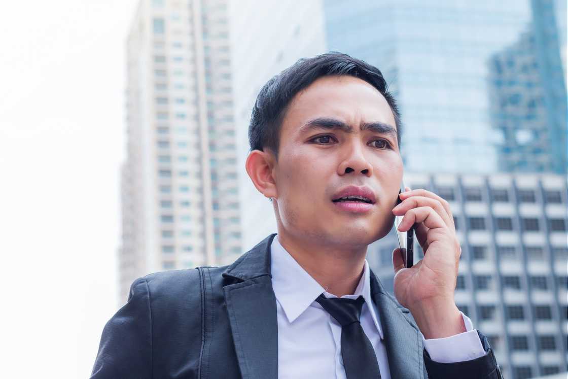 A disappointed businessman talking with smartphone outdoor