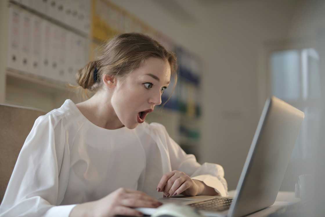 A woman looking at a laptop screen worried
