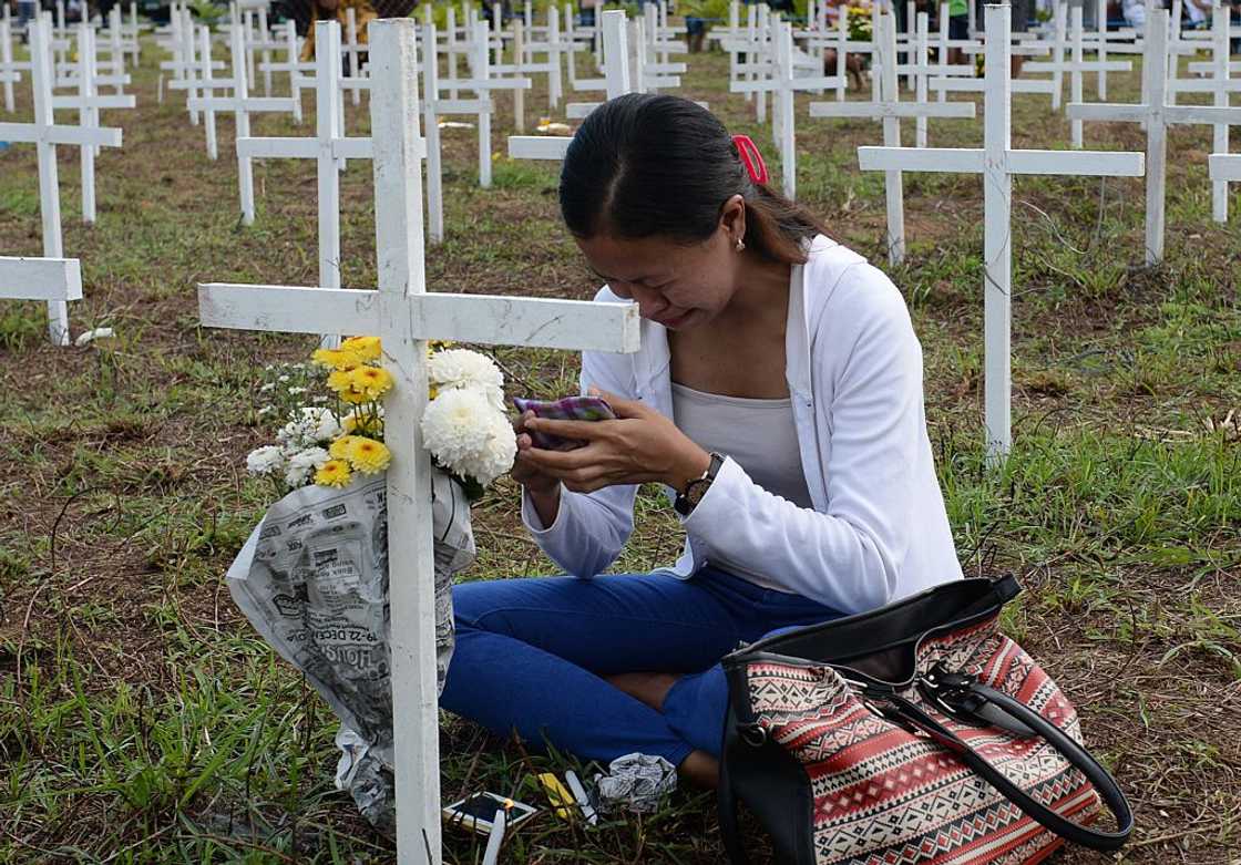 Woman cries at a loved one's grave. Woman cries at a loved one's grave.