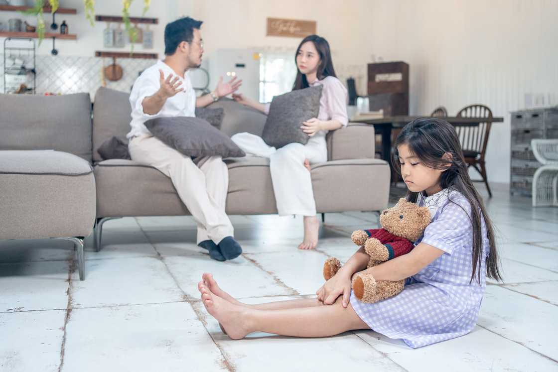 A couple arguing infront of a young girl