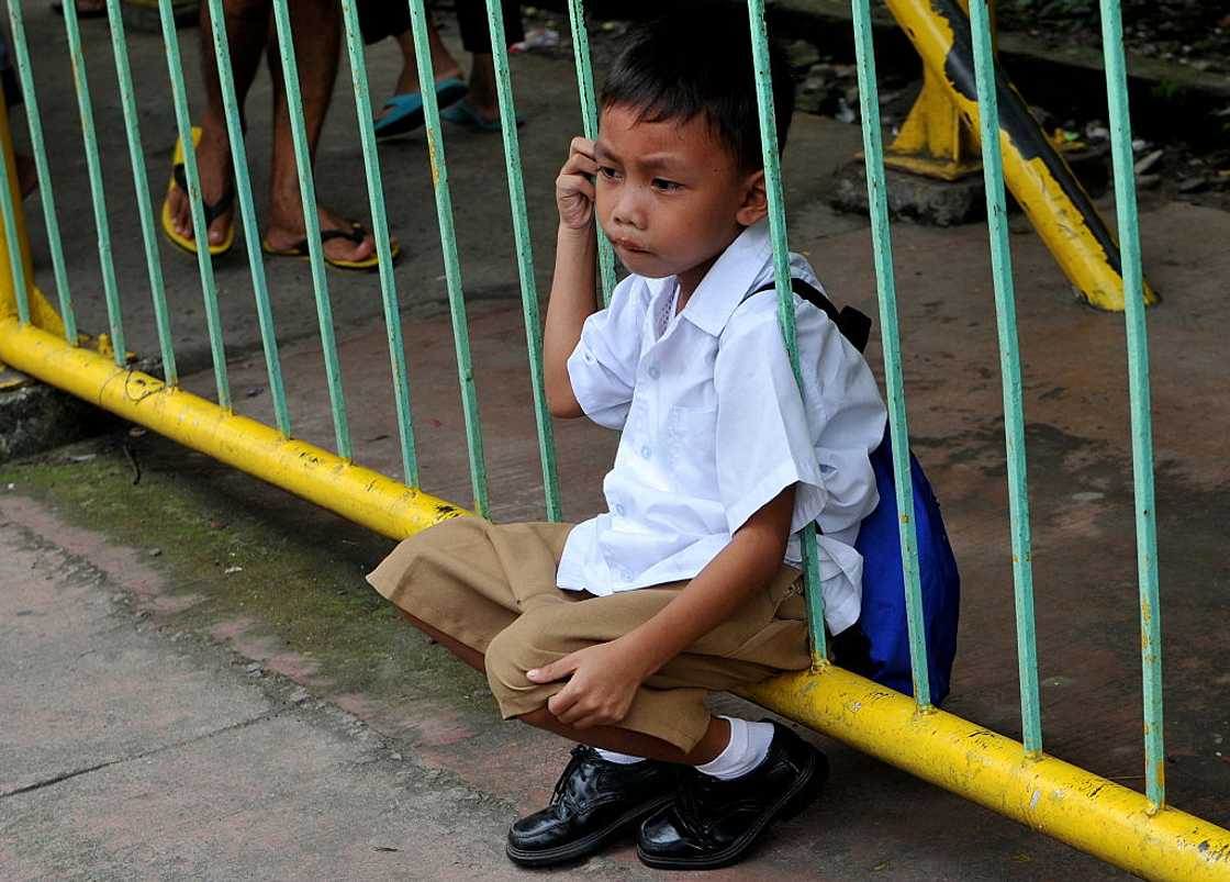 Schoolboy looking dejected outdoor. Schoolboy looking dejected outdoor.