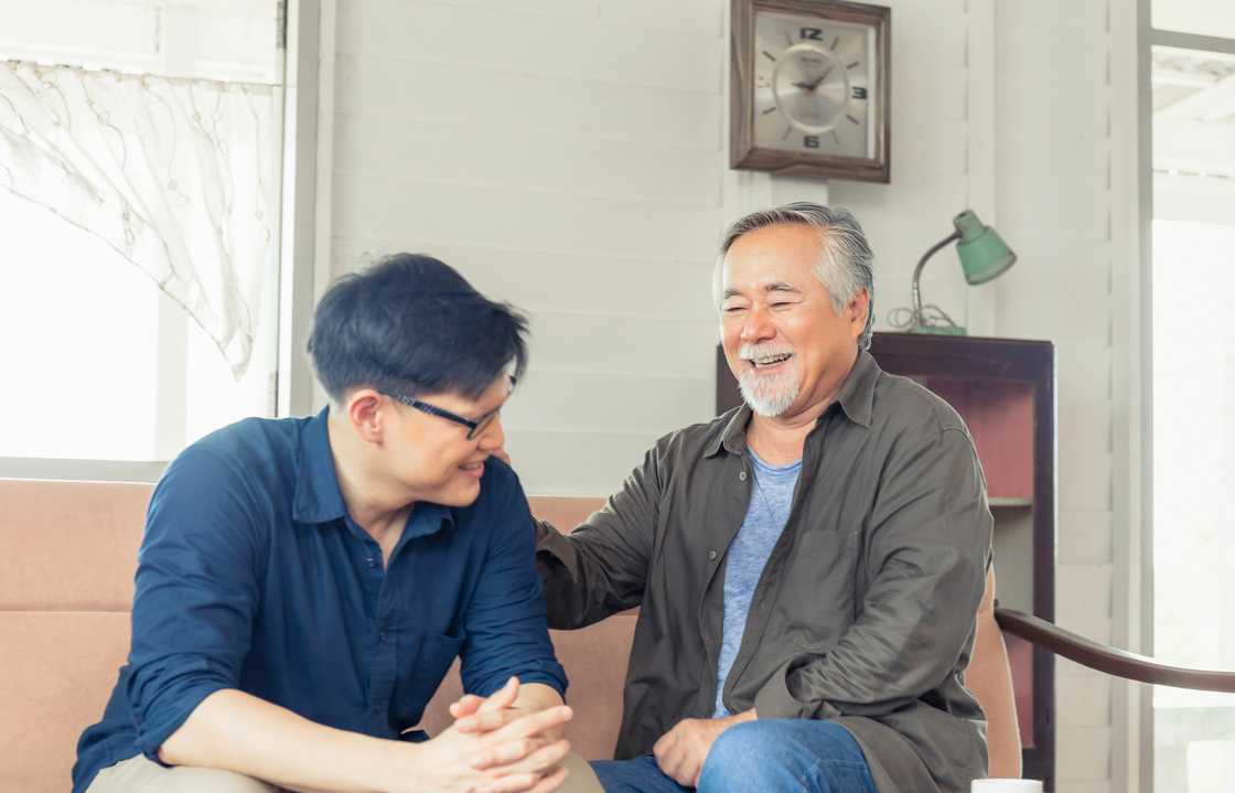 A father laughing with his son in the living room