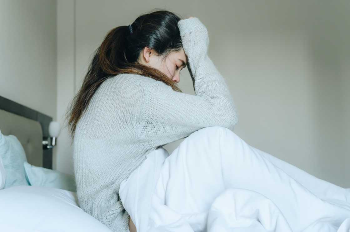 A sad and lonely young woman sitting on bed A sad and lonely young woman sitting on bed