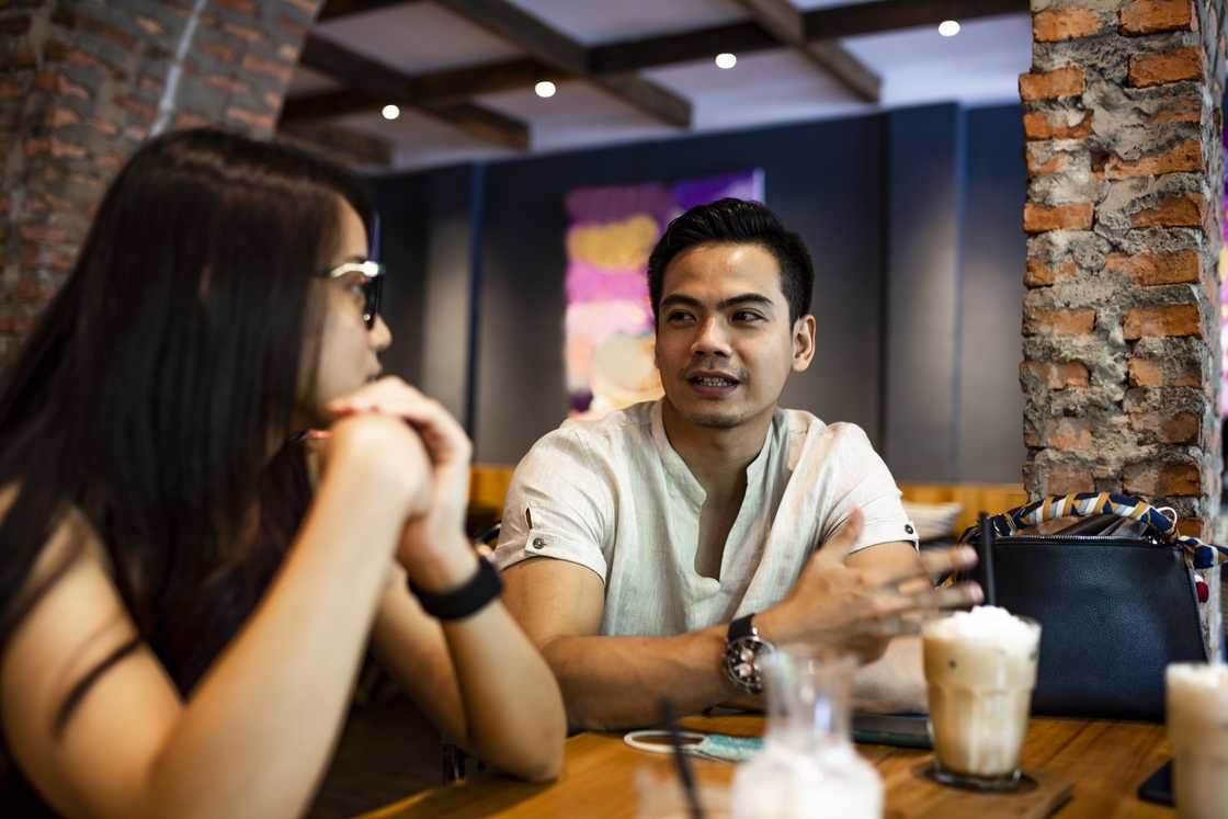 A man and a lady at a cafe chatting