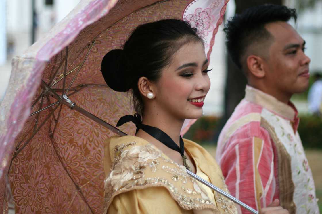 Woman holding umbrella outdoor with husband.