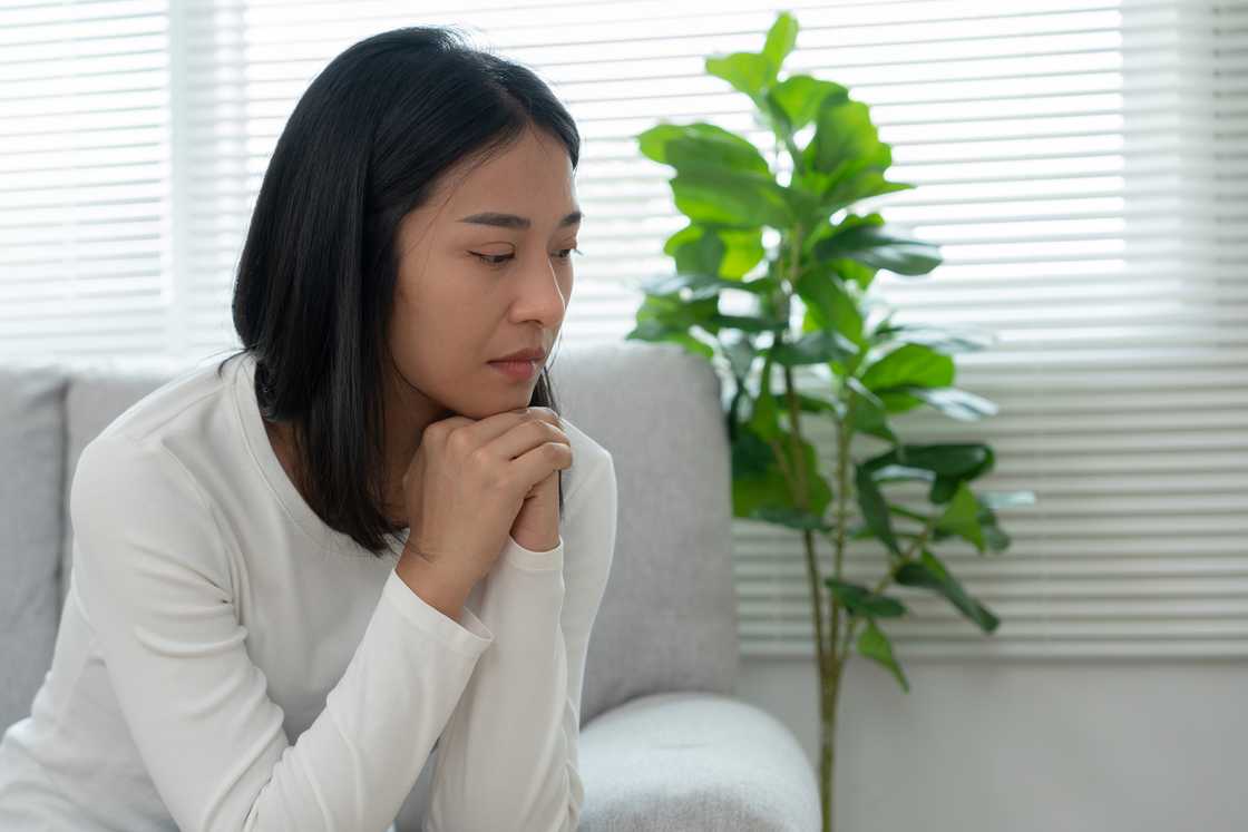 A woman thinking with hands on her chin